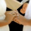 Couple exchanging rings at wedding ceremony.