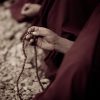 A monk hold mala on his hand