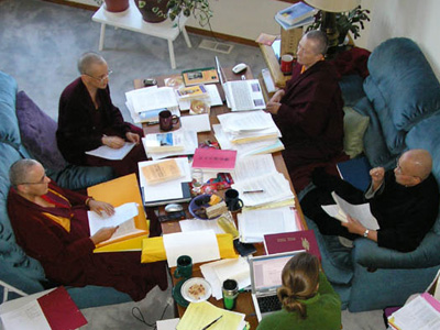 Ven. Chodron, Ven. Jampa Tsedroen , Ven. Heng-Ching Shih and Ven. Lekshe Tsomo sitting and discussing on a table full of papers.