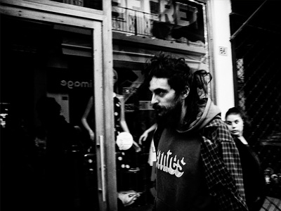 Man walking down street looking angry.