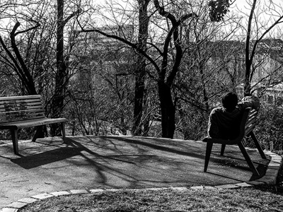 Homeless man lying on a park bench.