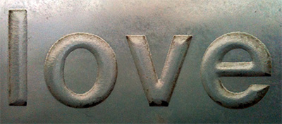 The word 'love' stamped into metal.