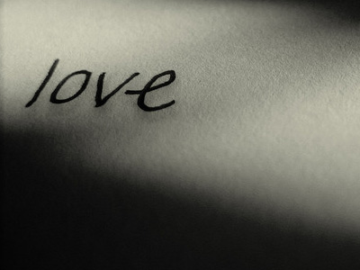 Black and white image of the word 'love' written by hand.
