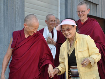 Die Ehrwuerdigen Chodron, Tarpa, und Semkye begleiten Ihre Heiligkeit Dagmo Kusho zum Gaestehaus des Klosters's.