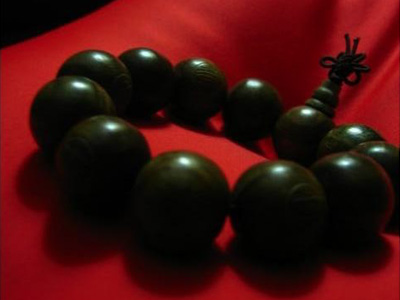 Brown mala on red cloth.