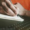 Man writing in a notebook.