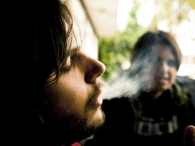 Young man with eyes closed, smoking.