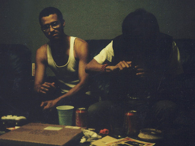 Two young men sitting on a couch smoking weed.