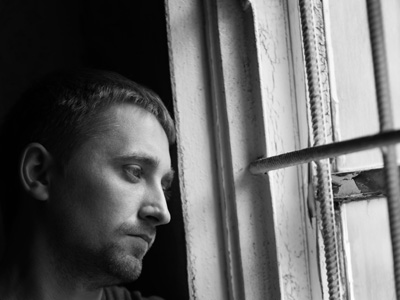 Sad man looking out window.