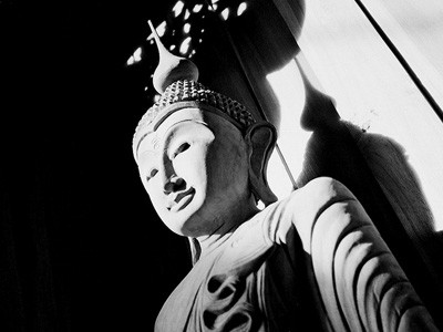 Černobílý obraz sochy Buddhy.