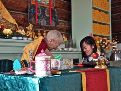 Abbey guest receiving a tsa-tsa from Venerable Chodron.