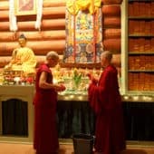 Venerables Semkye and Chonyi preparing offerings in front of the Abbey altar.