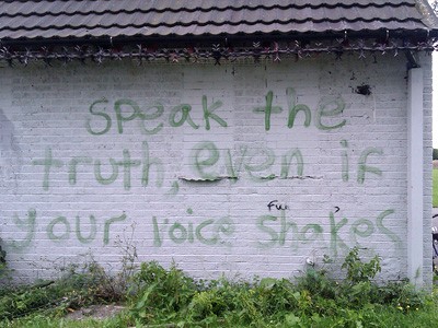 "Mów prawdę, nawet jeśli twój głos drży" namalowany na ścianie.