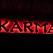 Red neon sign that says 'Karma'.