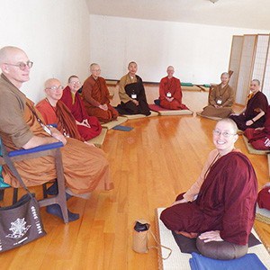 Buddhist monastics of different traditions sitting in a discussion group.