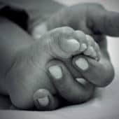 Baby's foot in a mother's hand.