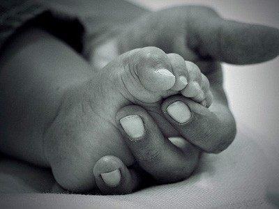 Baby's foot in a mother's hand.