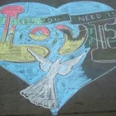 Sidewalk chalk drawing of a heart and the words 'All you need is love.'