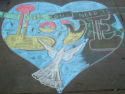 Kredą chodnikową rysunek serca i napis „Wszystko czego potrzebujesz to miłość”.