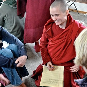 Venerable Jampa, smiling and talking to retreatants during group discussion.