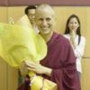 Venerable Chodron smiling and holding flowers at Tai Pei Buddhist Centre in Singapore.