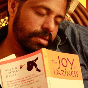 A man sleeping with a book: The Joy of Laziness.