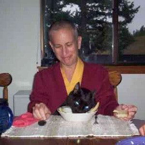 Venerable Chodron with the cat, Manjushri, eating breakfast together.