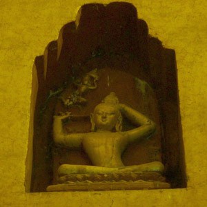 A yellow statute of prince siddhartha cutting of his hair, as a symbol of his renunciation.
