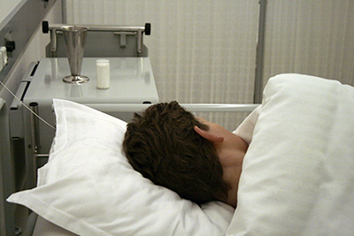 Man lying in hospital bed.