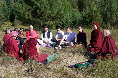 A group of monastics and laypeople outside having a group discussion.
