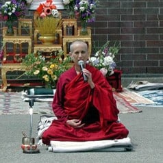Venerable Chodron in front of an altar, teaching.