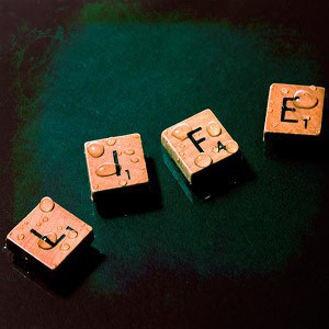 The words Life made up of Scrabble letters with water droplets on it.