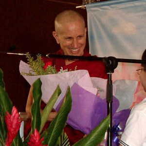 Venerable Chodron teaching in Singapore, smiling after being offered flowers.