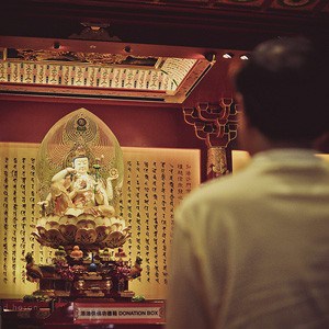 Practitioner in front of Buddha statue.