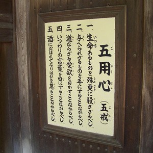 Five precepts in Japanese written on a board.