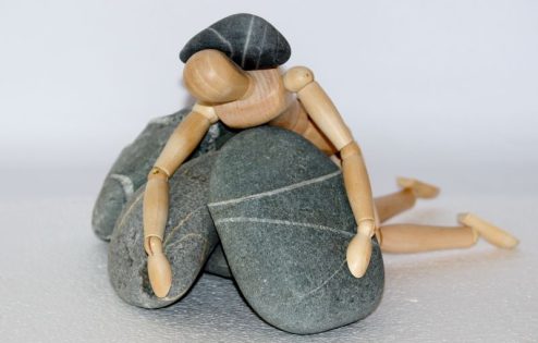 Stick man being crushed by rocks