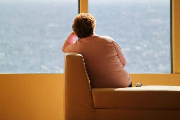 Woman sitting looking out he window at water
