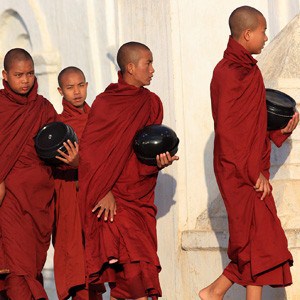 Mnisi buddyjscy niosący miskę, aby otrzymać ofiary.