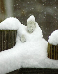 A statue of a buddha covered in snow.
