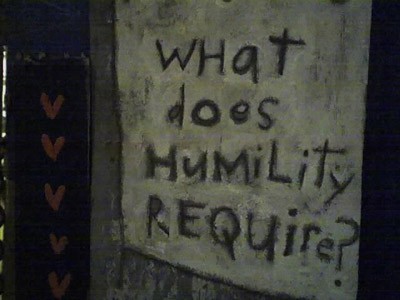 Słowa: Czego wymaga pokora?, wypisane na ścianie.