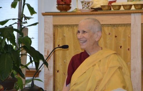 Venerable Chodron teaching the Dharma and smiling very happily.