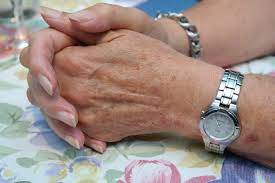 Older female hands clasping each other.