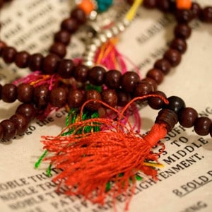 Rosewood mala, with a paper of Four Noble Truths described on it.