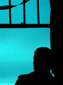 Man looking out window.