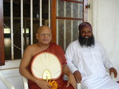 Ein buddhistischer Mönch und ein muslimischer Priester sitzen zusammen.
