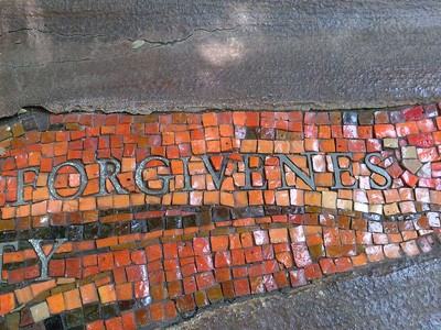 The word 'forgiveness' written into red and orange tile.