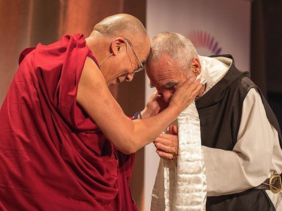 His Holiness touching his forehead to the head of a Catholic monk.