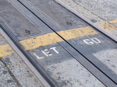 The words 'Let go' painted on cable car tracks.