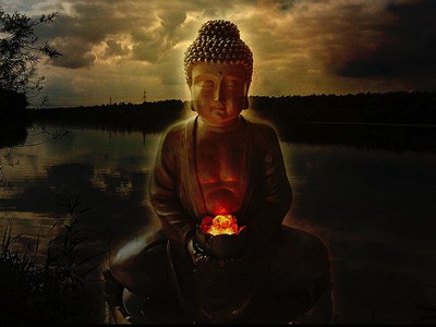 Buddha statue in silhouette against sunset.