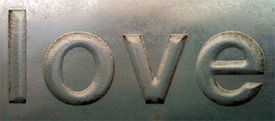 The word 'love' stamped into metal.